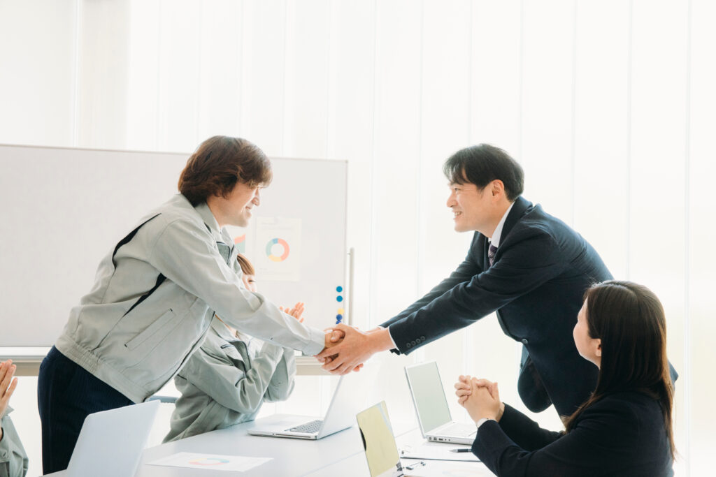 「M&A・事業承継・100億宣言の支援や相談を表す担当者同士が握手している画像
